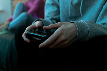 game controller, hands holding, video game, indoor setting, close-up, gaming, controller, person playing, indoor gaming, video game controller, hands close-up