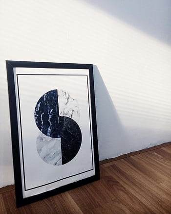 Černobílý abstraktní malba, orámované minimalistické umělecké dílo, slunný pokoj, dřevěná podlaha, abstraktní umělecká díla, černý rám, moderní umění, interiér, nástěnné umění, geometrický design, textura mramoru