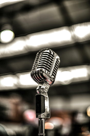 silver microphone, vintage microphone, chrome microphone, close-up microphone, stage background, music themes, vintage chrome, microphone stand, stage lights, blurred background, music equipment
