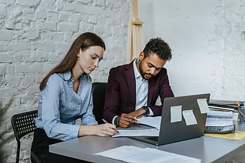 man en vrouw werken, professionals aan het bureau, Moderne kantooromgeving, samenwerkingswerk, zakelijke bijeenkomst, kantooromgeving, samenspel, professionele kleding, laptop en documenten, Werkplekinteractie
