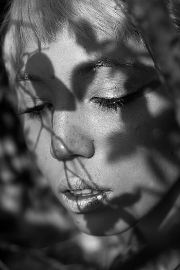 Schwarzweiss-Portrait, Gesicht der Frau, Blattschatten, natürliche Schatten, künstlerische Fotografie, monochromes Bild, Nahaufnahmeportrait, Fotografie im Freien, Serendene Expression, sanfte Frau, Schattenspiel