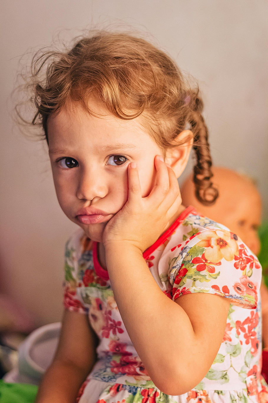 thoughtful toddler, white and red floral dress, cap-sleeved dress, charming portrait, colorful floral dress, indoors, young girl, child fashion, toddler fashion, indoor portrait, floral pattern