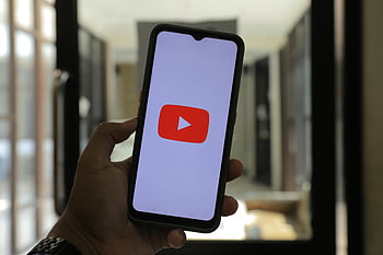 logo youtube, smartfon, trzymanie ręki, Czarny telefon komórkowy, zbliżenie, dobrze oświetlony pokój, telefon komórkowy, Aplikacja YouTube, urzadzenie cyfrowe, ustawienie wewnętrzne, technologia