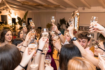 happy friends, clinking glasses, champagne, restaurant, lively celebration, indoor celebration, cheerful toast, group celebration, friends toasting, party atmosphere, social gathering