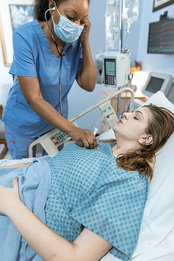 zdravotní sestřička, stetoskop, trpělivý srdeční tep, pacientka, nemocniční postel, zdravotní péče, Zdravotník, klinické prostředí, vyšetření pacienta, lékařské vybavení, Zdravotní zařízení