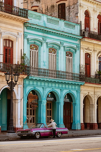 Havana, Cuba, colorful buildings, vintage architecture, classic car, street scene, man standing, pink car, vibrant colors, colonial buildings, Caribbean culture