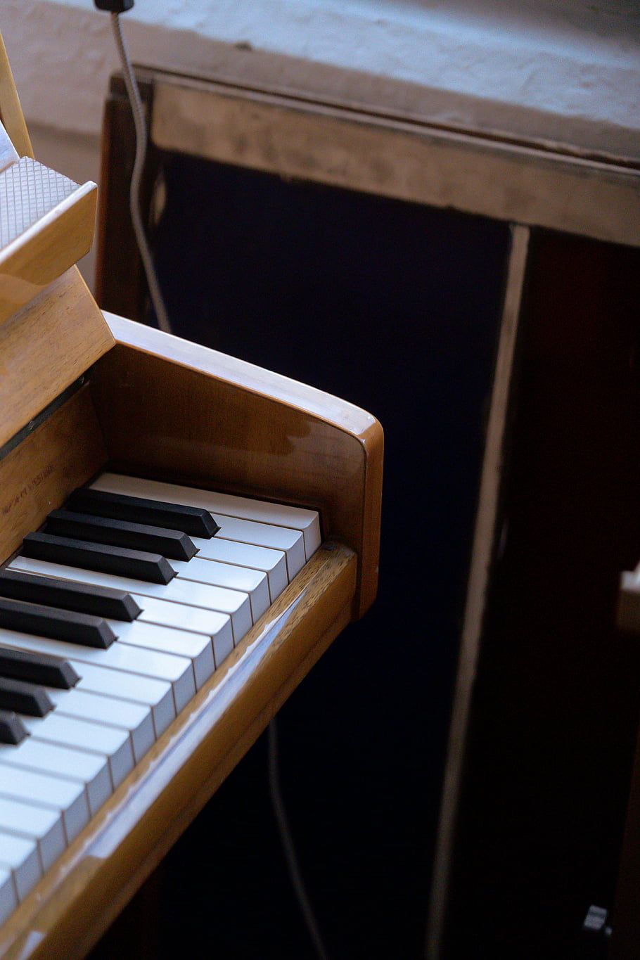 retro klavír, ořechové barvy dřeva, klasické dřevěné piano, Vintage Charm, elegantní design, slunný pokoj, hudební nástroj, starožitný klavír, klávesy piana, dřevěný nábytek, interiér