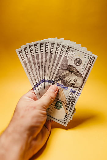 Americké dolarové bankovky, ruka drží peníze, nás měny, jasně žluté pozadí, symbol bohatství, finanční koncept, detailní fotografie, 100 dolarové bankovky, Finanční úspěch, Zobrazení peněz, hotovostní bohatství