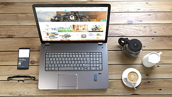srebrny laptop, filiżanka kawy, smartfon, okulary, drewniane biurko, widok z góry, obszar roboczy, technologia, konfiguracja biurowa, wydajność, nowoczesne biurko