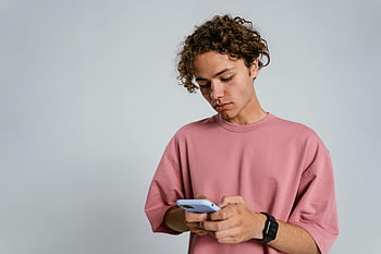 νεαρός, σγουρά μαλλιά, smartphone, ροζ μπλουζάκι, μέσα, χρησιμοποιώντας το τηλέφωνο, Casual ντύσιμο, νέος άνδρας, ψηφιακή συσκευή, μοντέρνα τεχνολογία, ΤΡΟΠΟΣ ΖΩΗΣ