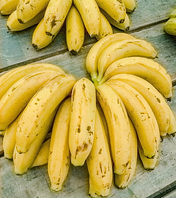 Bananen, reife Bananen, gelbe Bananen, Bananenstaude, Nahaufnahme Bananen, verwitterter Holztisch, Mongaguá Brasilien, Fruchtphotographie, Bananen-Nahaufnahme, Bananenstillleben
