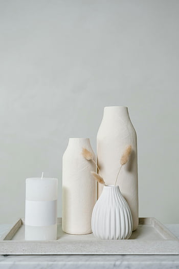 ceramic vases, candle, neutral tones, elegant still life, tray, minimalist decor, white vases, modern home decor, simple aesthetic, decorative objects, neutral background