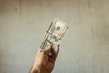 Man met dollarbiljetten, ons dollar bankbiljetten, rijkdomsymbool, neutrale achtergrond, hand met geld, stapel dollars, financieel succes, contant geld in de hand, geld vasthouden, Rijkdom vertegenwoordiging, dollar biljetten