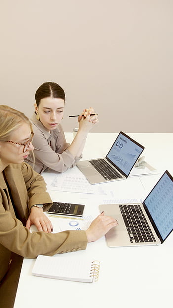 Frauen arbeiten zusammen, Geschäftsfrau, Laptops, Finanzdokumente, Büroeinstellung, Daten analysieren, Zusammenspiel, Professionelle Zusammenarbeit, Büroarbeit, Geschäftstreffen, Finanzanalyse