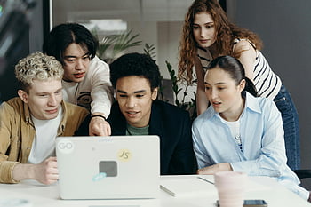 A laptopra néző emberek, Változatos csoport, Fiatal szakemberek, együttműködő, laptop projekt, modern iroda, csapatmunka, csoportbeszélgetés, irodai környezet, technológia, együttműködés
