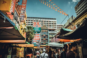 urban market, colorful shops, city setting, bustling street, signage, buildings, flea market, Confucian PSDN, festive decorations, outdoor market, vibrant scene