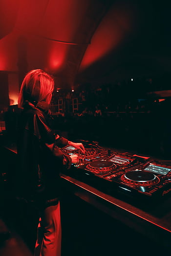 dj femminile, discoteca, luci rosse, tracce di miscelazione, Atmosfera vivace, giradischi, cuffie, esibizione musicale, stand dj, folla, Evento night club