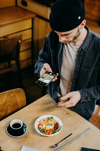 man taking photo, breakfast, coffee, smartphone, cozy cafe, meal photography, table setting, casual dining, food photography, morning routine, cafe atmosphere