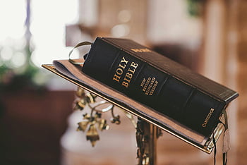 Holy Bible, open Bible, Bible on stand, church interior, faith and spirituality, religious text, New Revised Standard Version, church decor, spiritual symbol, religious book, Bible stand