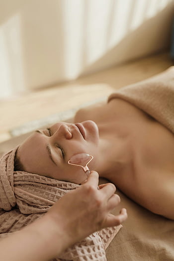 facial masaj, jad roller, Setare spa, femeie relaxantă, tratament calmant, Terapie de înfrumusețare, îngrijirea pielii, Tratament de wellness, îngrijire facială, relaxare spa, Roller facial