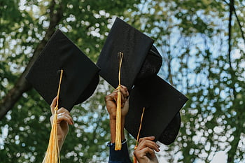 graduation caps, hands holding caps, celebration, success symbol, outdoor graduation, graduation ceremony, academic achievement, graduation tassels, group celebration, graduation day, graduation photo