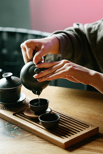 tea ceremony, pouring tea, teacups, teapot, wooden surface, traditional tea, close-up, tea preparation, tea culture, tea time, tea ritual