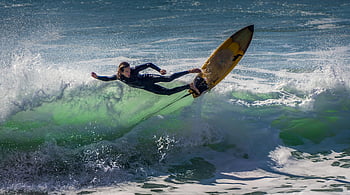 Surfen, Surfer, Ozean Wellen, helle Sonne, geschickte Manövrierung, aufregende Erfassung, Gelbes Surfbrett, Neoprenanzug, Action-Schuss, Wassersport, Strandaktivität