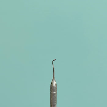 dental instrument, close-up, stainless steel, teal background, healthcare themes, minimalist, dental tool, medical equipment, dental care, dental hygiene, dental practice