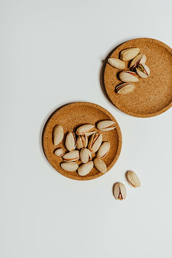 Pistazien, Brown Cork Untersetzer, Ansicht von oben, Minimalismus, weißer Hintergrund, Nüsse, Food-Fotografie, flach liegen, natürliche Texturen, Snack, gesundes Essen