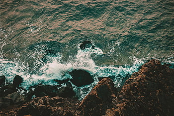 top view, rocky shore, aerial shot, waves crashing, rocky shoreline, nature's beauty, ocean waves, coastal landscape, natural scenery, sea waves, rocky coast