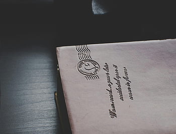 vintage envelope, postal markings, dark wooden surface, close-up, retro, mail, stamp, letter, old paper, handwriting, document
