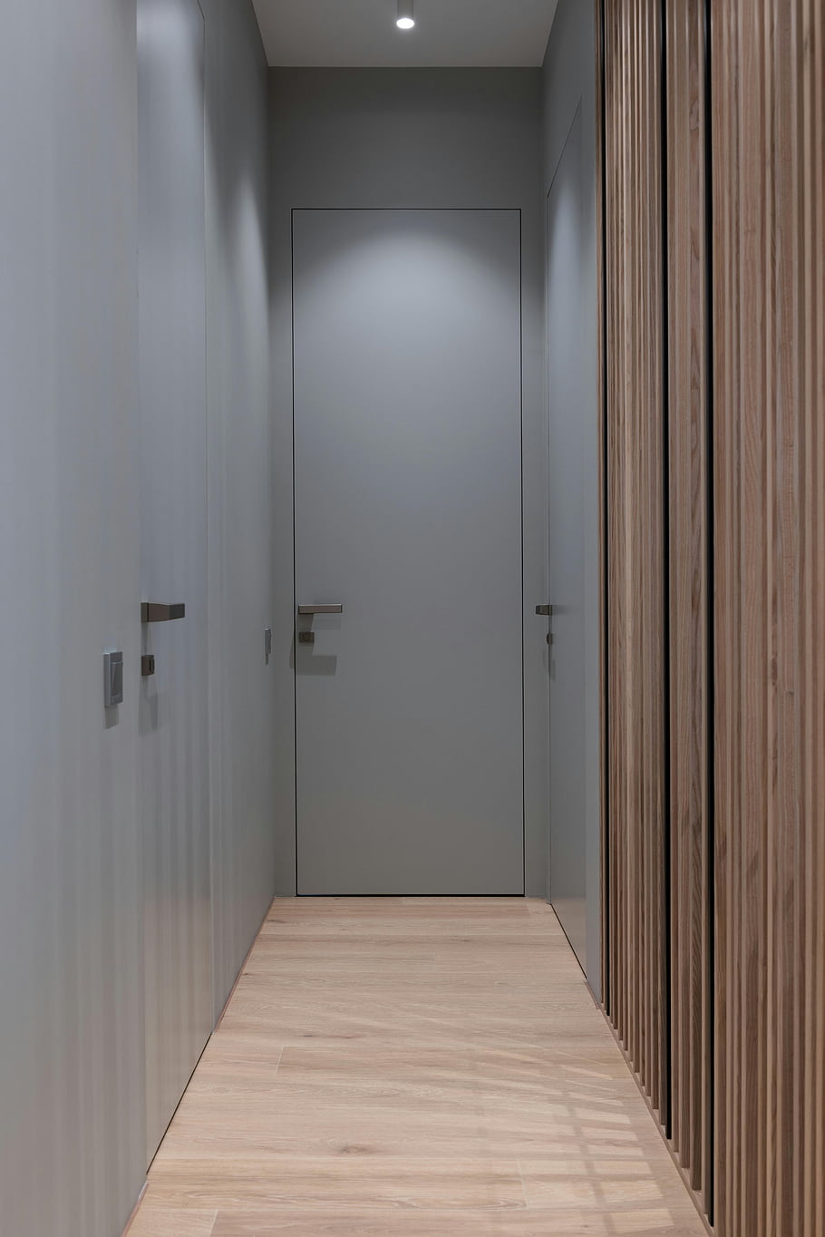 Moderní chodba, minimalistický design, elegantní design, moderní dekor, čisté linky, vnitřní chodba, Apartmánská chodba, Úzká chodba, dřevěné podlahy, šedé stěny, Moderní dveře