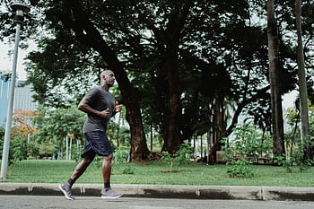 man running, gray t-shirt, black shorts, outdoor jogging, lush green park, fitness lifestyle, healthy lifestyle, man exercising, outdoor exercise, park run, active man
