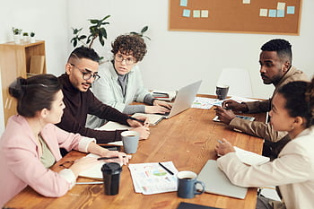 pertemuan tim, Grup Beragam, profesional, Diskusi Kolaboratif, tempat kerja, Meja konferensi, laptop, dokumen, lingkungan kantor, orang bisnis, sesi brainstorming
