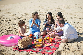 family picnic, sunny beach, Portugal, joyful gathering, beach picnic, family time, outdoor activity, sandy beach, picnic blanket, beach outing, family fun