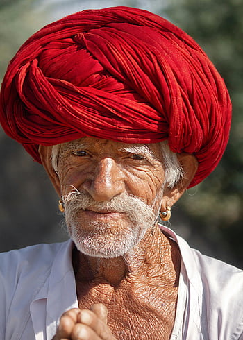 elderly man, red turban, traditional Indian culture, close-up portrait, vibrant red, Indian man, cultural attire, aged man, traditional headwear, white beard, traditional clothing