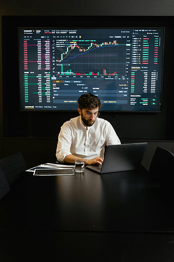 gerichte professionele man, laptop gebruiken, Analyse van trends op de aandelenmarkt, kantooromgeving, Gereikte grafieken, Financiële analyse, aandelenhandel, Zakelijke professional, marktgegevens, investeringsanalyse, kantoorwerk