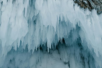 frozen icicles, close-up shot, cave entrance, winter setting, sharp icicles, dramatic close-up, ice formations, winter landscape, icy cave, frozen water, icicle details
