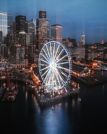 aerial view, lighted city, nighttime, illuminated Ferris wheel, waterfront, Seattle skyline, twilight, urban vibrance, cityscape, evening lights, waterfront city