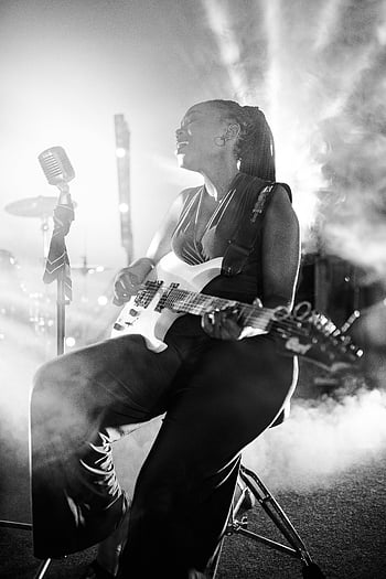 en blanco y negro, mujer tocando la guitarra, concierto ahumado, guitarra electrica, foto en escala de grises, entorno de concierto, actuación musical, música en vivo, puesta en escena, Músico femenino, fotografía en blanco y negro