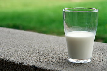 čiré mléčné sklo, kamenná římsa, rozmazané zelené pozadí, venku, čiré sklo, mléko, kamenný povrch, zelené pozadí, venkovní nastavení