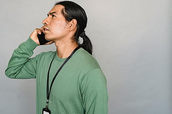 Indiánský muž, konverzace smartphonu, zelený svetr, boční pohled, šedé pozadí, vážný výraz, telefonát, mužský portrét, ležérní oblečení, Vnitřní nastavení, etnický jedinec
