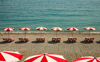 Italian beach, red and white umbrellas, summer sun, clean beach, peaceful scene, beach umbrellas, beach chairs, seaside view, coastal scene, beach relaxation, beach vacation