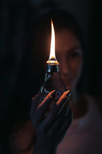 女性、 照明付きオイルランプ、 輝く炎、 電球、 温かい雰囲気、 不思議な雰囲気、 暗い背景、 手持ちランプ、 ソフトフォーカス、 屋内照明、 芸術的な写真