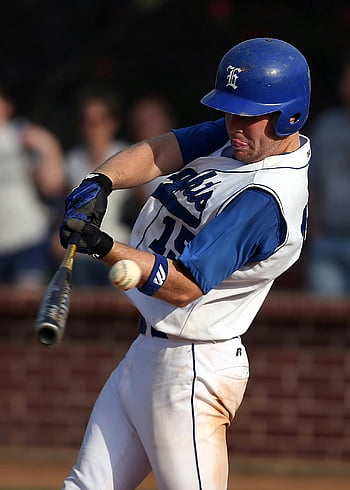 baseball player, batting, dynamic shot, blue and white uniform, swinging bat, game action, sports photography, baseball action, player in motion, sports uniform, baseball helmet