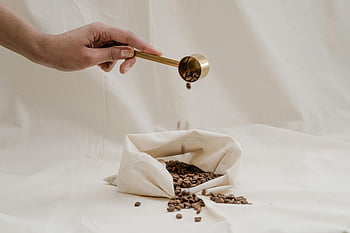 Kávová zrna, Zlatá lopatka, Ekologická taška, měkké pozadí, nalévání kávy, Ruční držení kopečky, Příprava kávy, udržitelné balení, eko taška