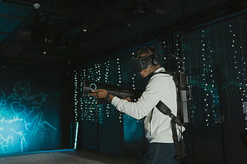 vr auricolare, giochi di realtà virtuale, uomo adulto, arma simulata, esperienza di gioco, tecnologia immersiva, intrattenimento interattivo, ambiente virtuale, Tecnologia di gioco, Esperienza di realtà virtuale, gioco vr