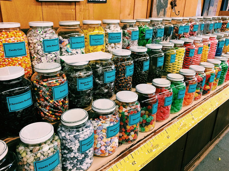barevné sladkosti, Skleněné sklenice, různé bonbóny, sklad police, sladká kukuřice, želé, arašídové máslo taffy, solná voda taffy, Čokoládové děti, Maple mátové korálky, kapky koření