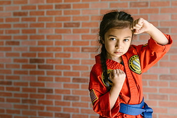 karate, mladá dívka, odhodlaný, halový trénink, cihlová zeď, bojová umění, karate uniforma, modrý pás, praxe, zaměřené, dívčí síla
