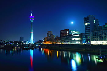 Rheinturm, Düsseldorf skyline, nighttime view, illuminated Rhine Tower, river reflection, cityscape, urban night scene, modern architecture, Rhine river, city lights, night photography